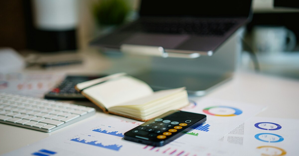 A planning desk with financial charts, a notebook and calculator.